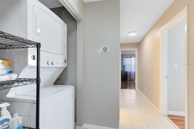 laundry area featuring light hardwood / wood-style floors and stacked washer / dryer