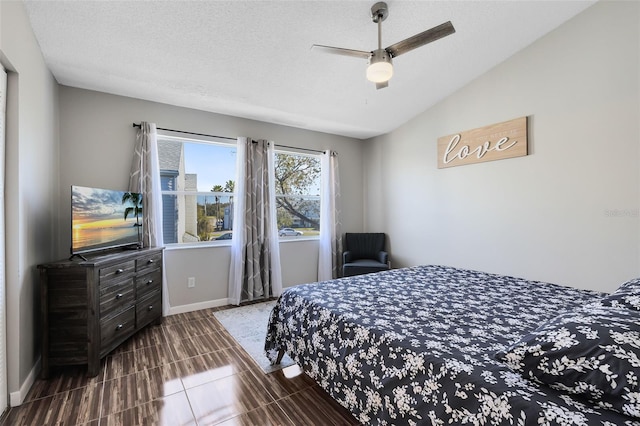 bedroom with a textured ceiling, ceiling fan, tile patterned floors, and lofted ceiling