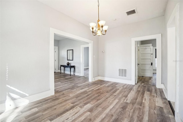 unfurnished dining area featuring hardwood / wood-style floors and a notable chandelier