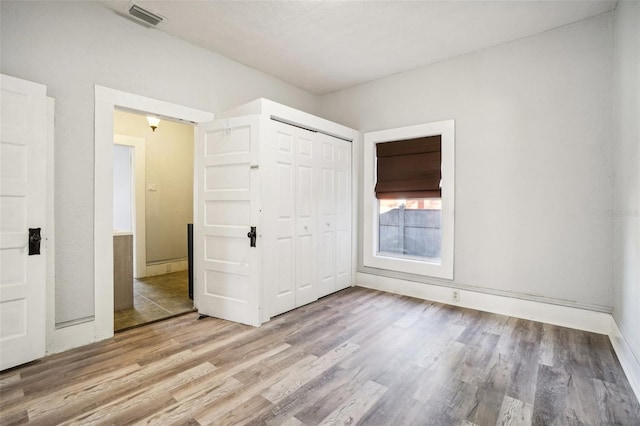 unfurnished bedroom with light wood-type flooring and a closet