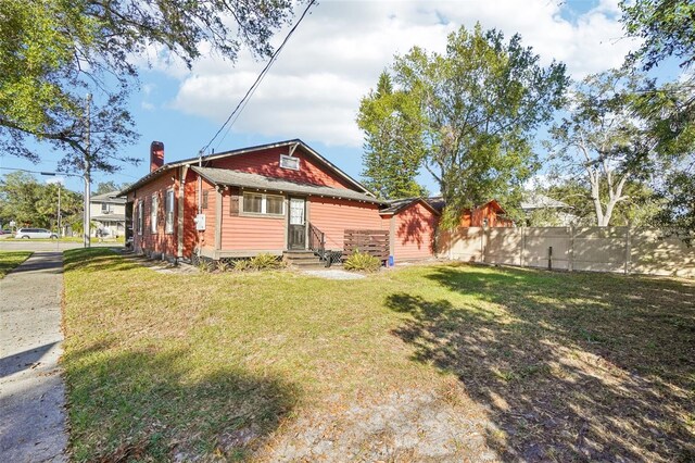 rear view of property with a lawn