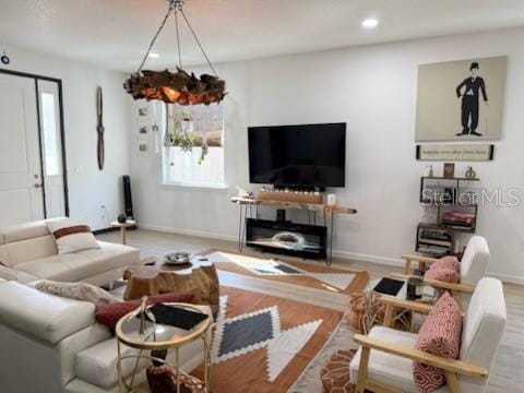 living room with light hardwood / wood-style floors and an inviting chandelier