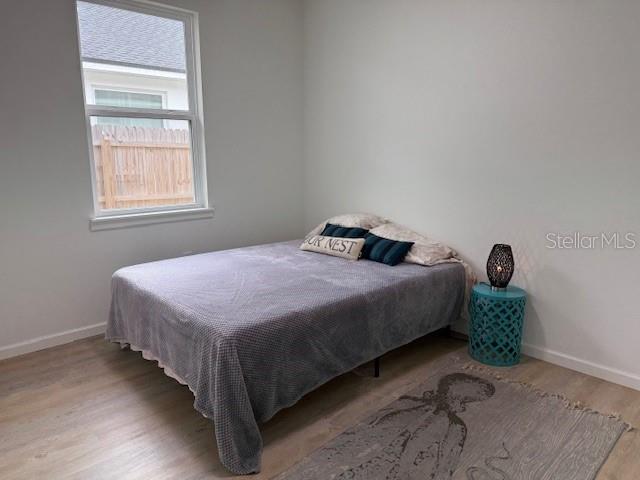 bedroom featuring hardwood / wood-style floors and multiple windows