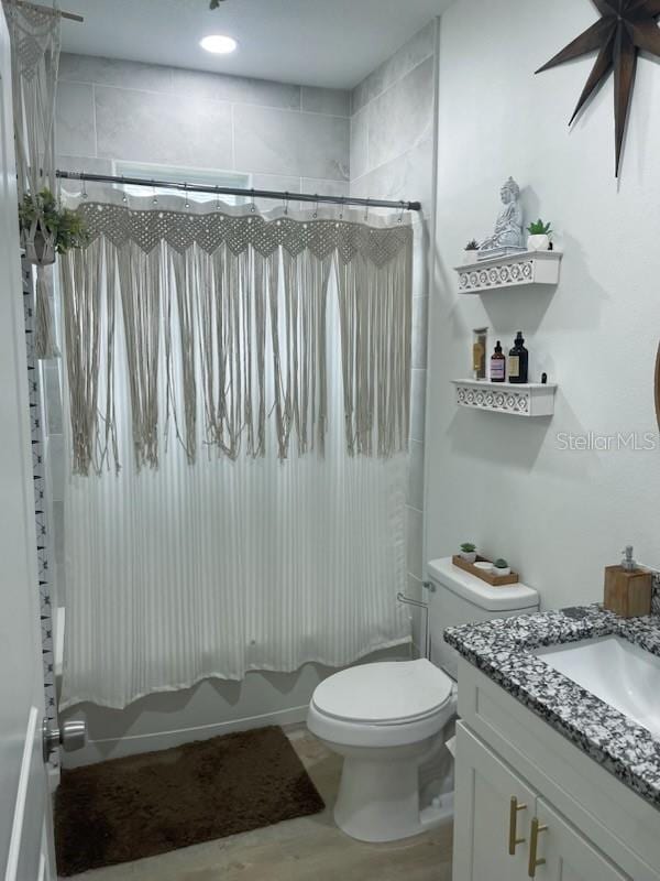 full bathroom with shower / bath combination with curtain, vanity, and toilet