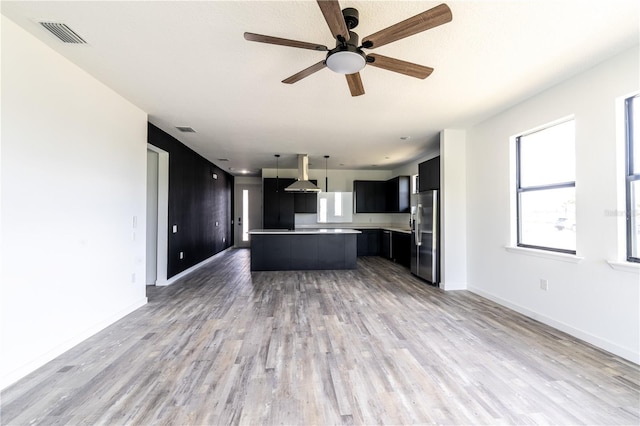 unfurnished living room with hardwood / wood-style flooring and ceiling fan