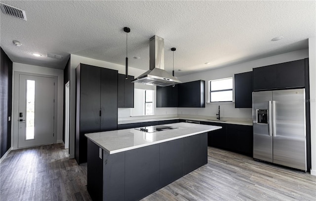 kitchen with a center island, light hardwood / wood-style flooring, stainless steel refrigerator with ice dispenser, pendant lighting, and island range hood