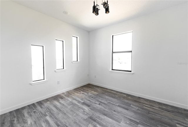 spare room with plenty of natural light and dark wood-type flooring