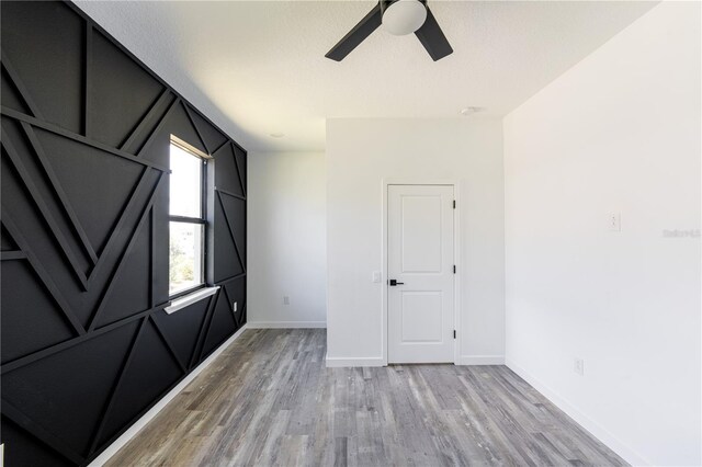 empty room featuring hardwood / wood-style flooring, ceiling fan, and a textured ceiling