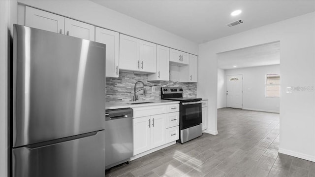 kitchen featuring light hardwood / wood-style flooring, stainless steel appliances, white cabinetry, and sink