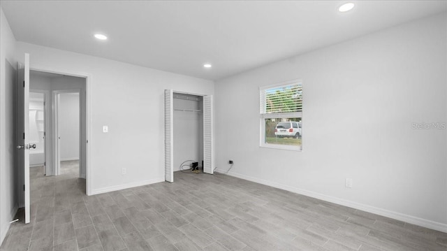 unfurnished bedroom featuring a closet and light wood-type flooring