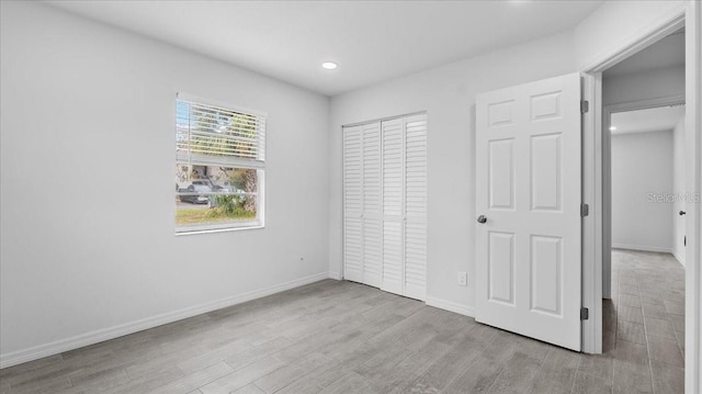 unfurnished bedroom featuring a closet and light hardwood / wood-style flooring