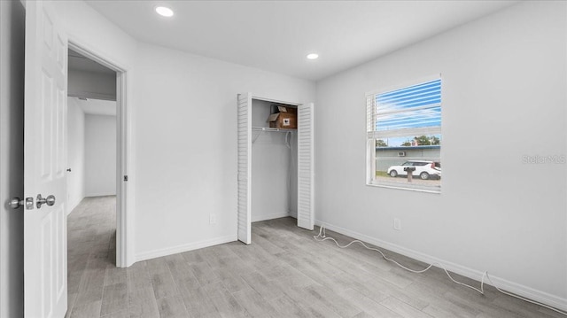 unfurnished bedroom featuring a closet and light hardwood / wood-style floors