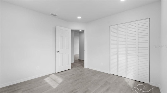 unfurnished bedroom featuring a closet and light hardwood / wood-style floors