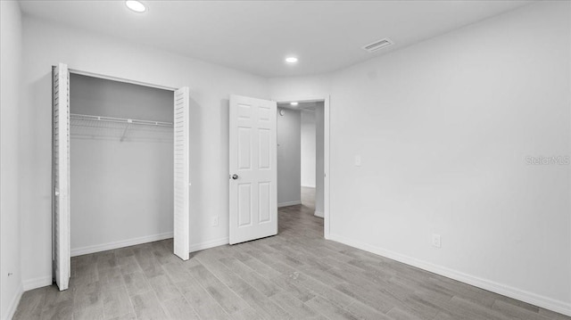 unfurnished bedroom with light hardwood / wood-style floors and a closet