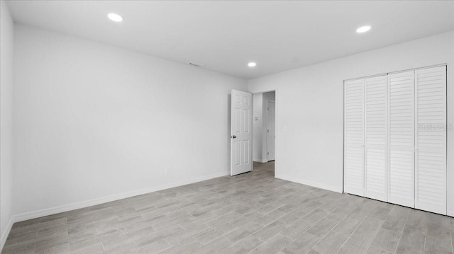 unfurnished bedroom featuring light wood-type flooring and a closet