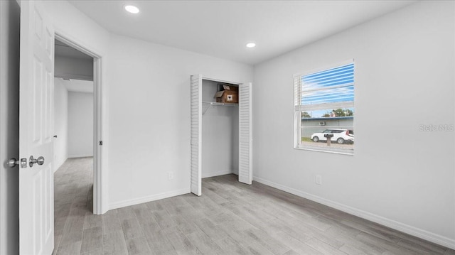 unfurnished bedroom featuring light hardwood / wood-style floors and a closet