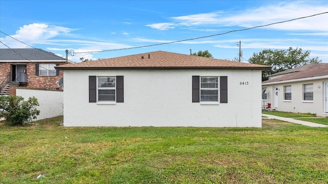 view of side of home with a yard