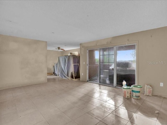 empty room featuring ceiling fan and a textured ceiling