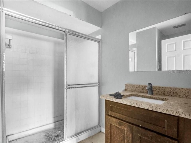 bathroom featuring vanity and a shower with shower door