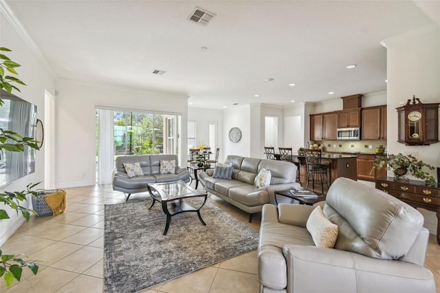 living room with light tile patterned floors and ornamental molding