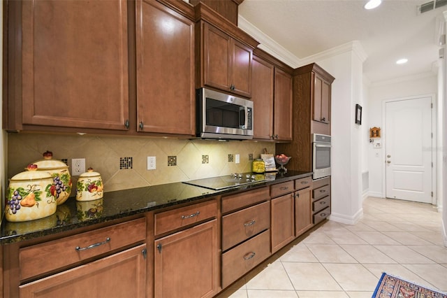 kitchen featuring dark stone countertops, light tile patterned floors, crown molding, and appliances with stainless steel finishes