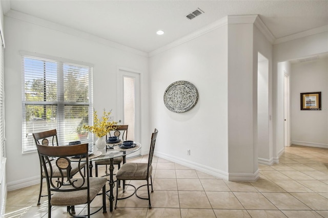 dining space featuring a healthy amount of sunlight, light tile patterned flooring, and ornamental molding