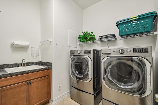 laundry area featuring washer and clothes dryer, light tile patterned floors, and sink