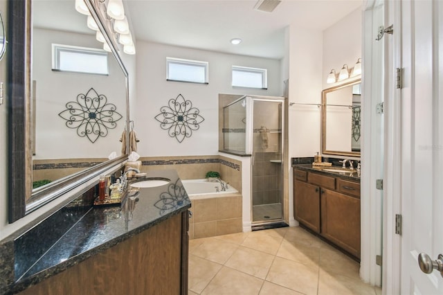 bathroom featuring tile patterned flooring, shower with separate bathtub, and vanity