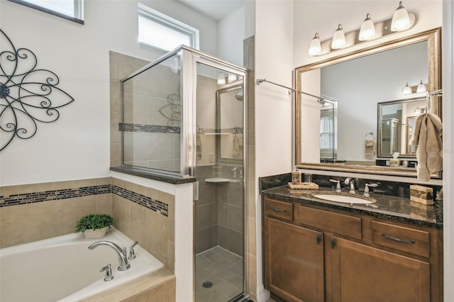 bathroom with separate shower and tub, plenty of natural light, and vanity