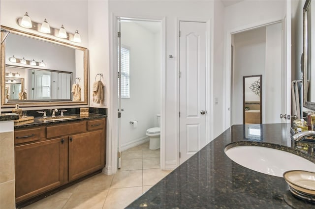 bathroom featuring tile patterned flooring, vanity, and toilet