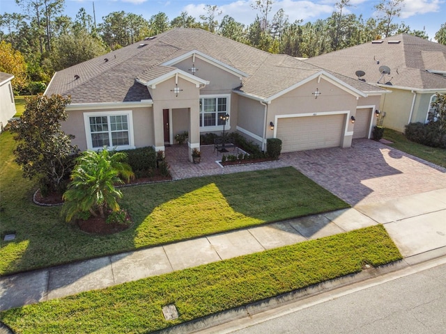 ranch-style home featuring a garage and a front lawn