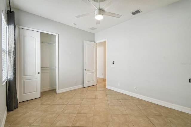 unfurnished bedroom with light tile patterned floors, a closet, and ceiling fan