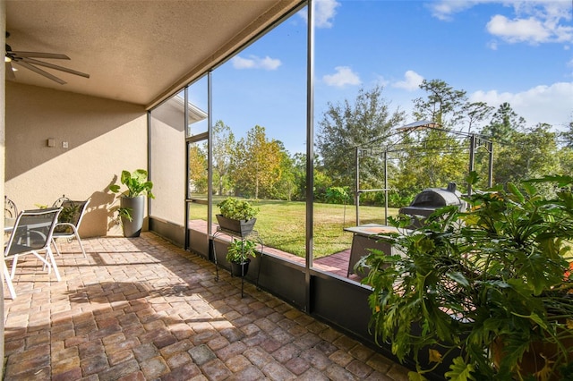 unfurnished sunroom featuring ceiling fan