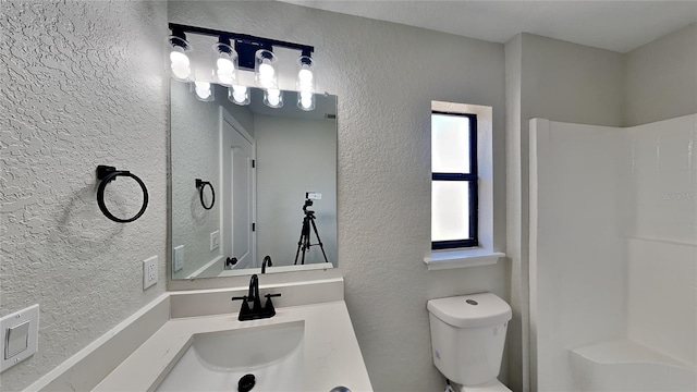 bathroom featuring vanity, toilet, and a shower