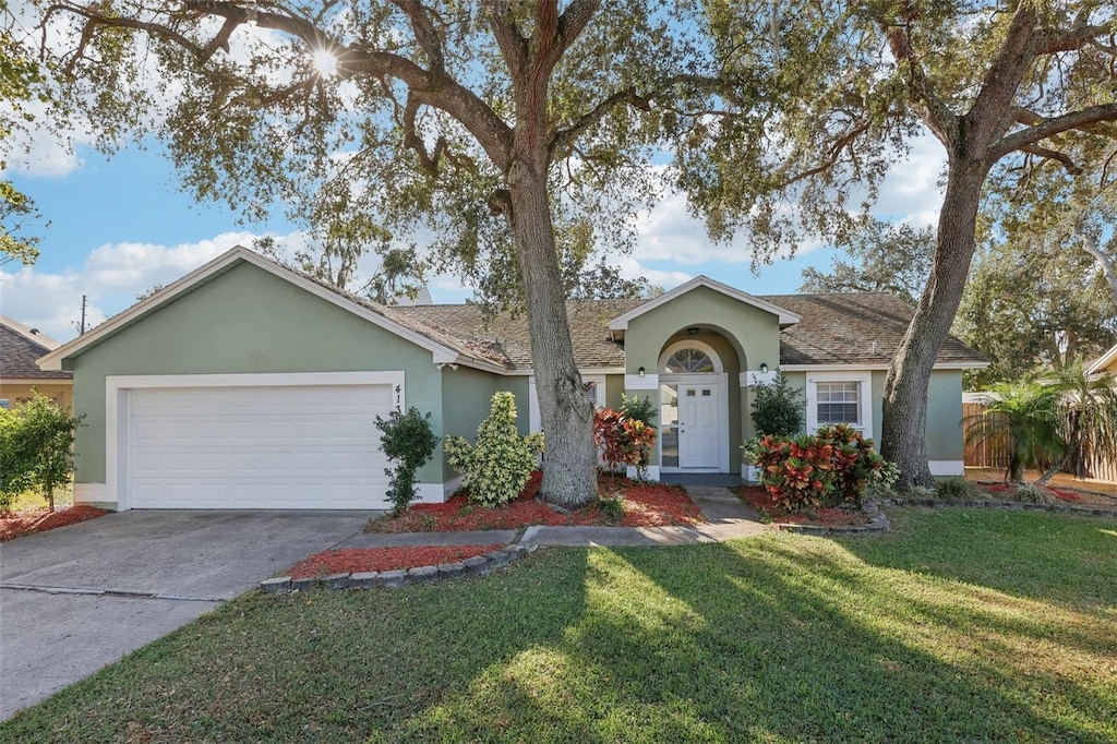 ranch-style house with a garage and a front yard