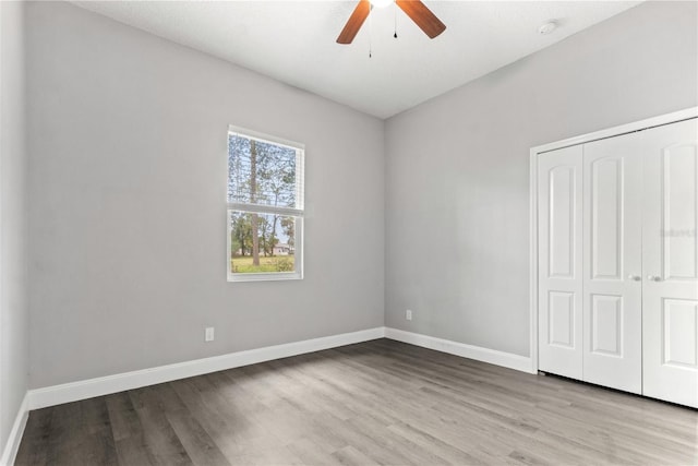 unfurnished bedroom featuring a closet, light hardwood / wood-style floors, and ceiling fan