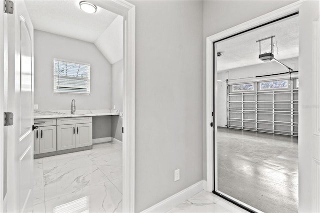 bathroom featuring vanity, a textured ceiling, and vaulted ceiling