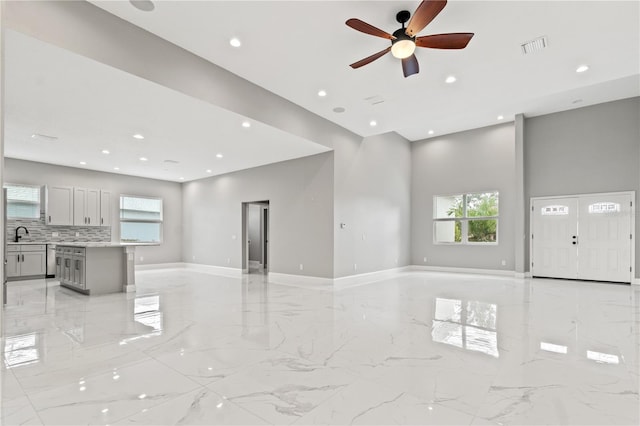 living room featuring marble finish floor, plenty of natural light, visible vents, and recessed lighting