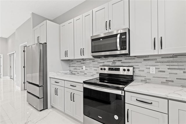 kitchen featuring light stone countertops, white cabinetry, marble finish floor, appliances with stainless steel finishes, and decorative backsplash