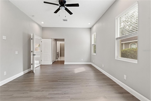 interior space with wood finished floors, visible vents, and baseboards