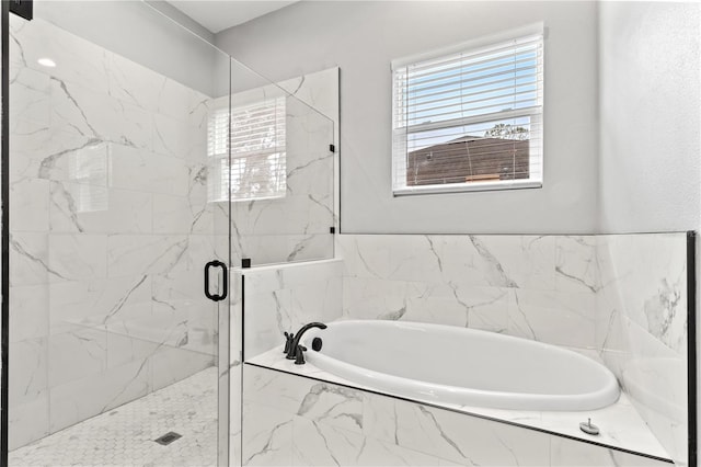 bathroom with a garden tub, a marble finish shower, and a wealth of natural light