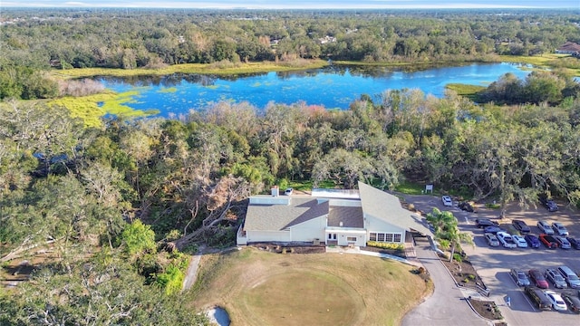 birds eye view of property with a water view and a wooded view