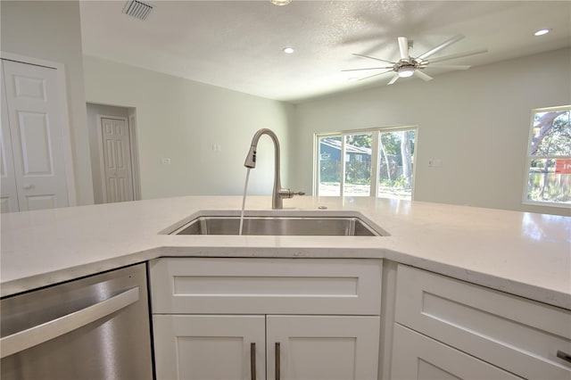 kitchen featuring white cabinetry, dishwasher, sink, and a textured ceiling