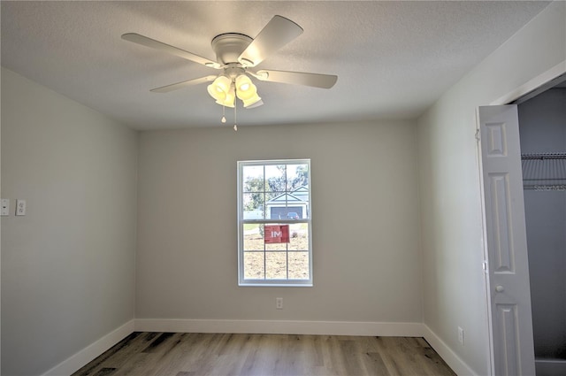 spare room featuring light hardwood / wood-style flooring and ceiling fan