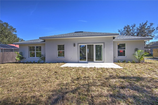 rear view of house with a patio and a lawn