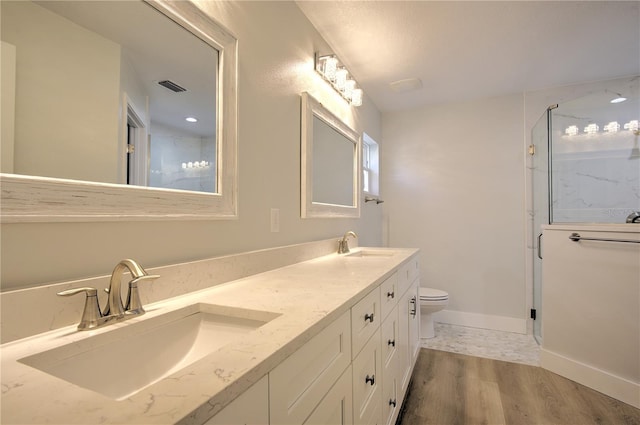 bathroom with wood-type flooring, toilet, a shower with door, and vanity