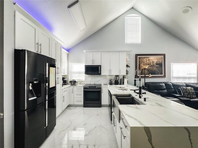 3383 Westchester Square Blvd Unit 202, Orlando, FL 32835 - kitchen with black appliances, a peninsula, white cabinets, light marble finish flooring, and light stone countertops