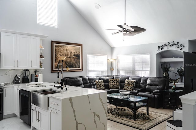 kitchen with white cabinetry, dishwasher, high vaulted ceiling, and light stone countertops