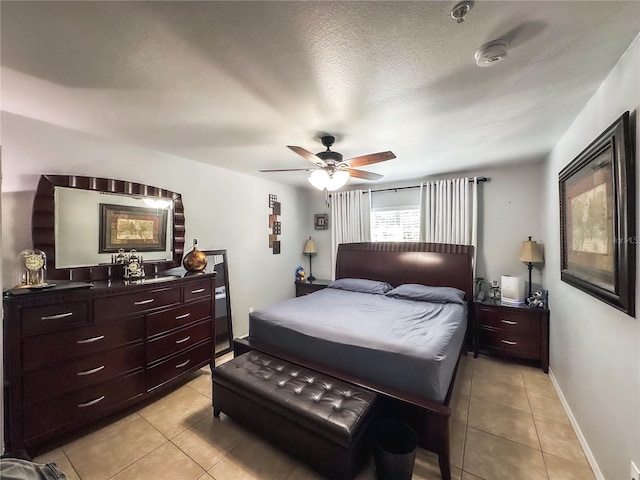 tiled bedroom with ceiling fan and a textured ceiling