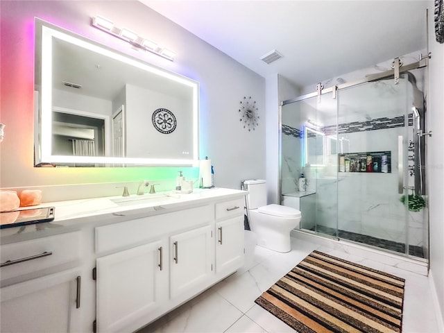 bathroom featuring tile patterned floors, vanity, toilet, and a shower with door